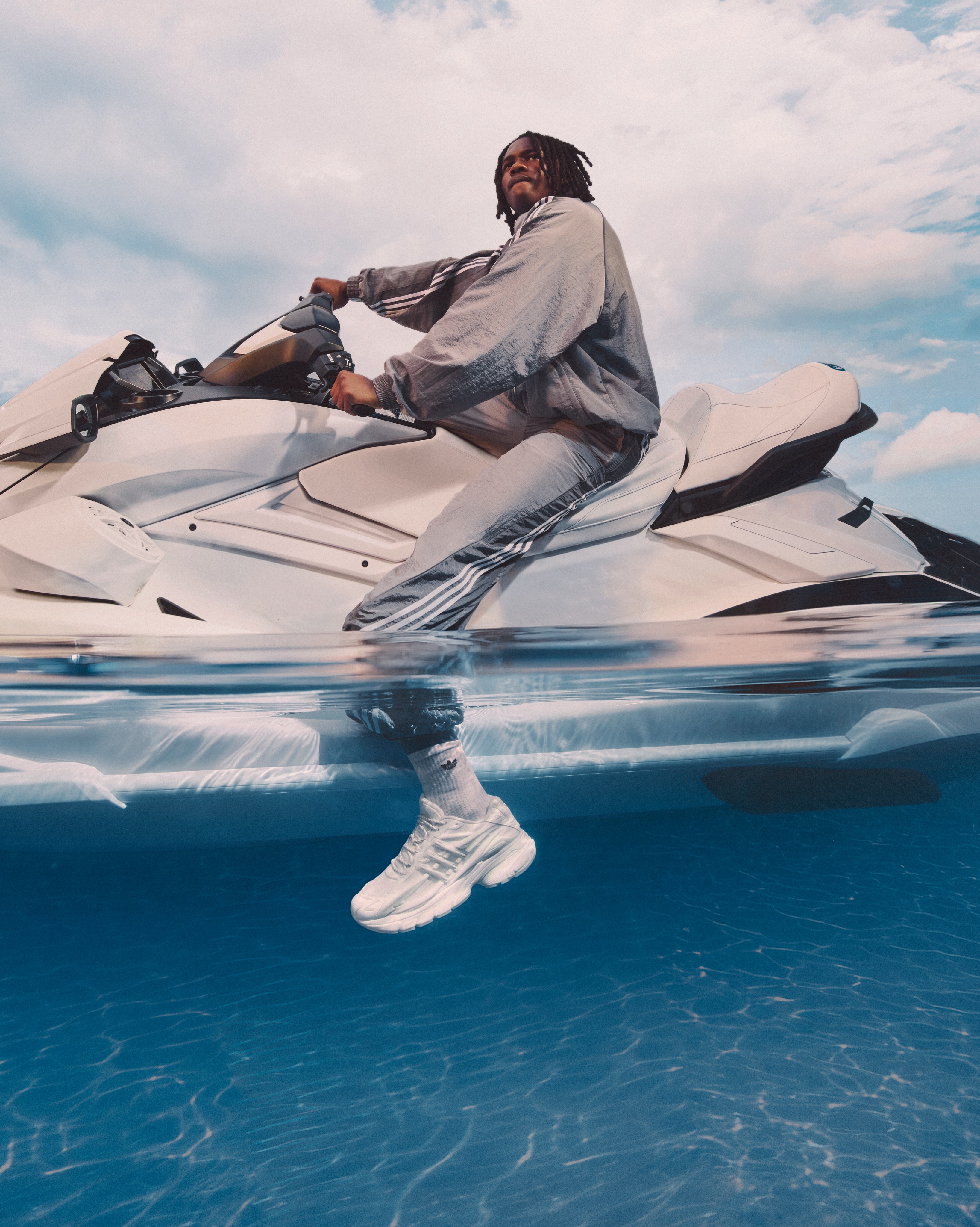 Adistar Jellyfish sneaker dangling over water from a jet ski