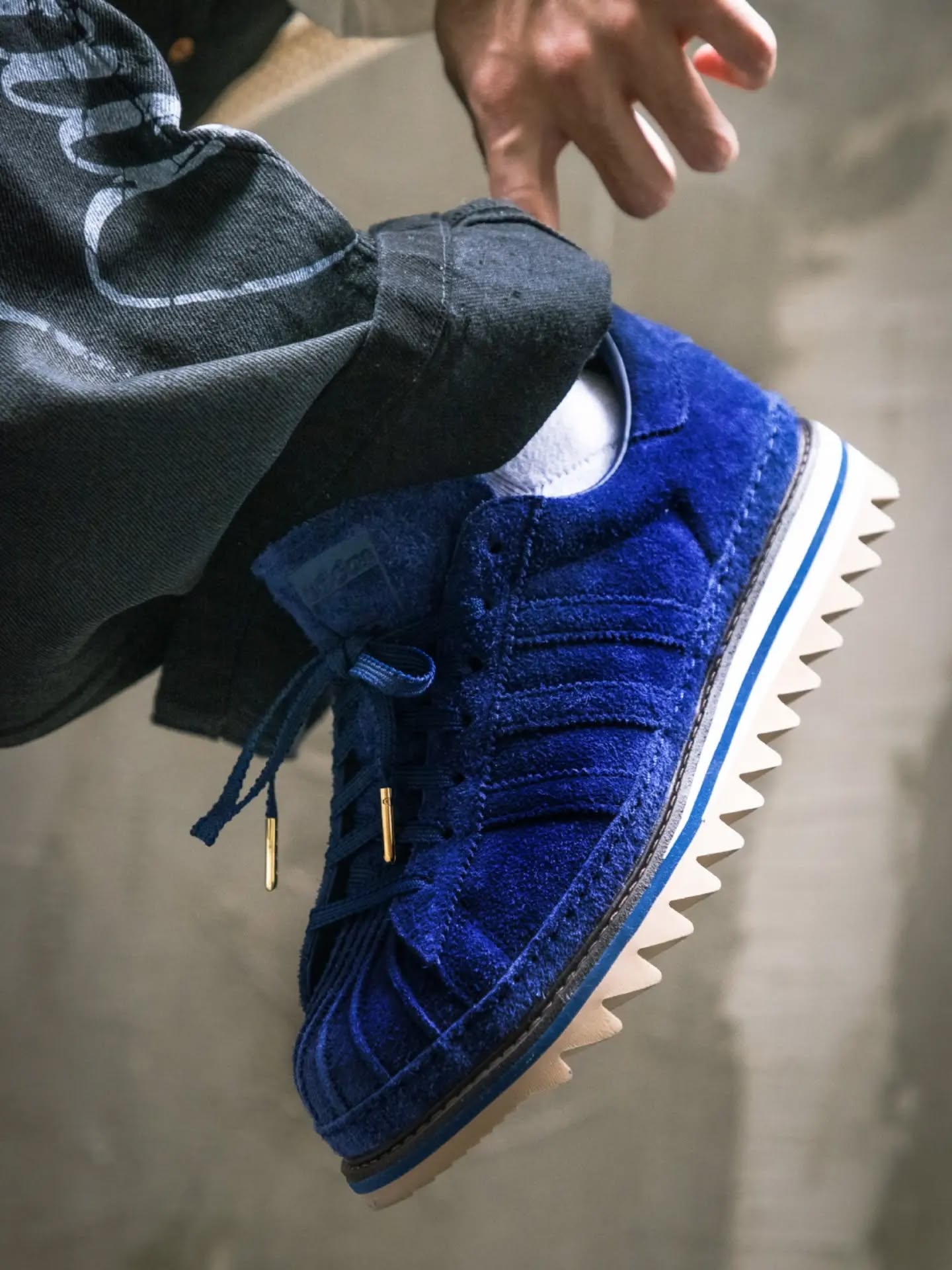 Close-up of the blue suede CLOT x adidas Superstar with sawtooth outsole
