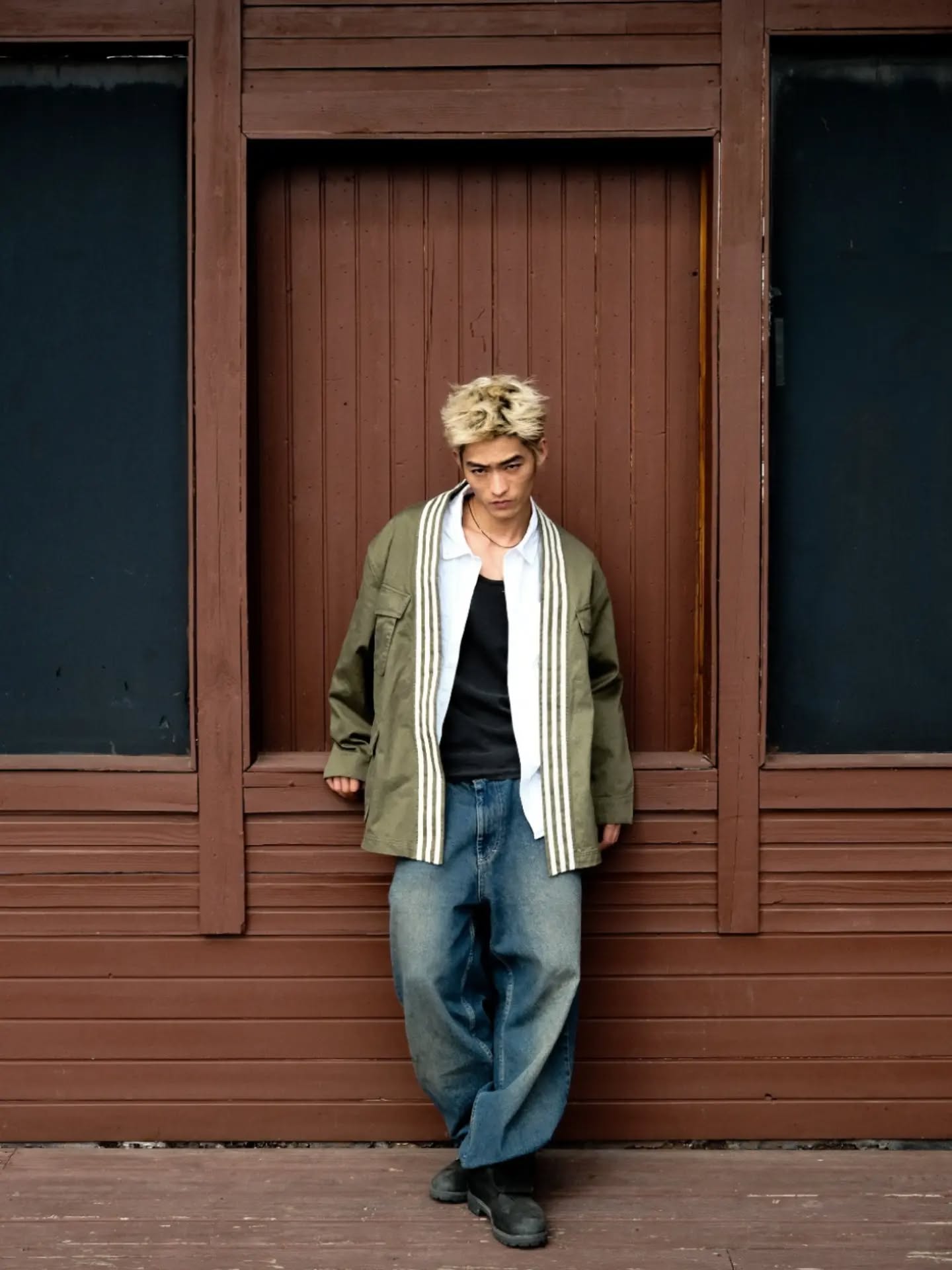 Model wearing the olive Utility Wrap Jacket with three stripes