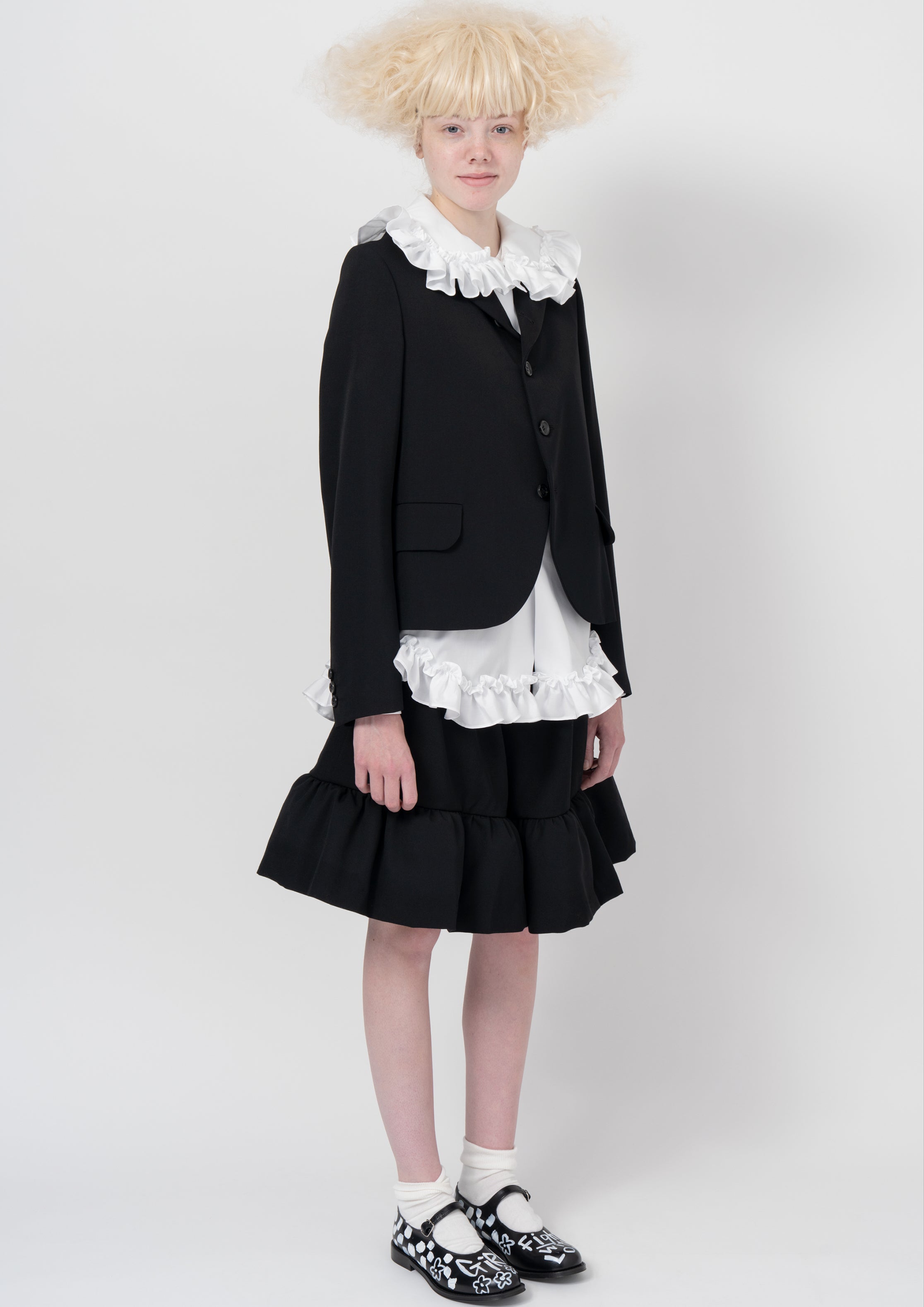 Suspender skirt with white round-collar shirt and bow-print handbag