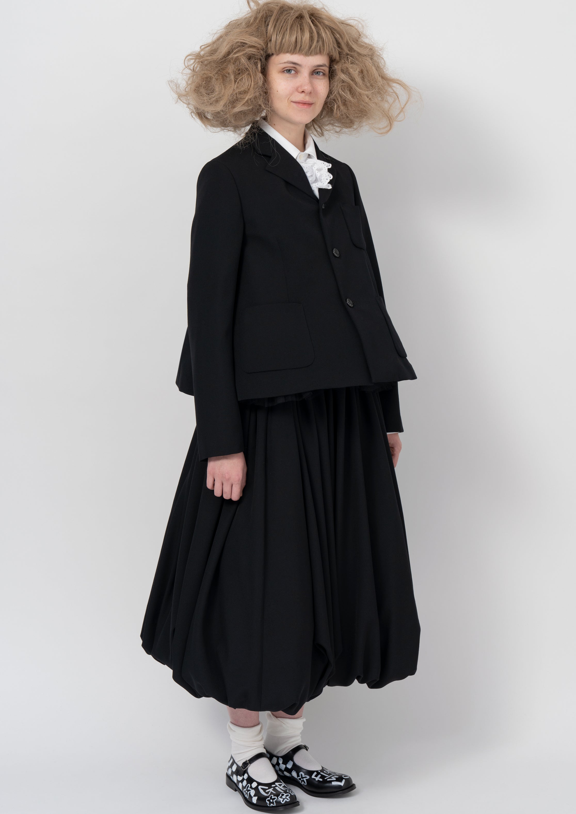 Black jacket with balloon skirt, lace jabot and painted shoes