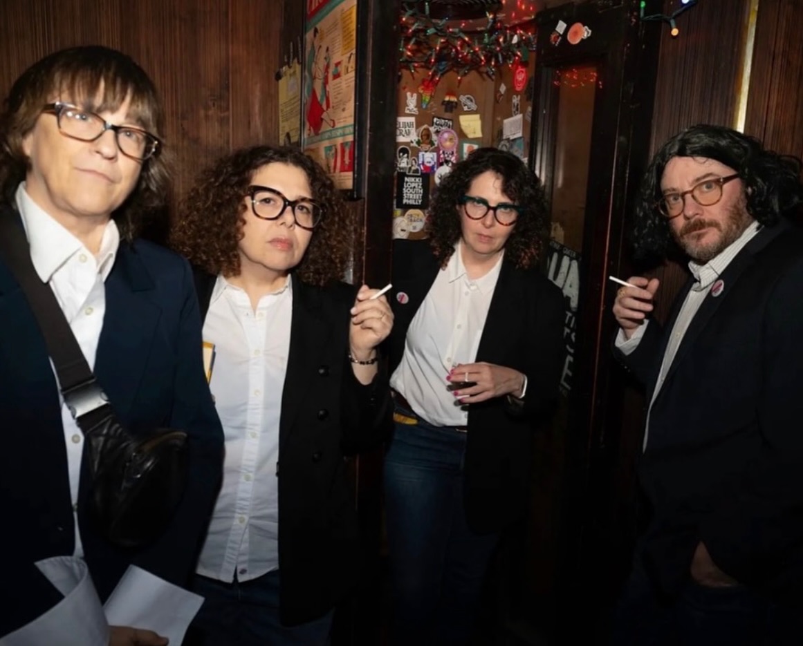 Four guests dressed as Fran Lebowitz holding candy cigarettes