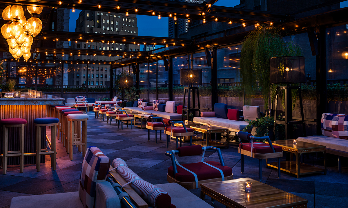 Magic Hour rooftop lounge at dusk with seating and string lights