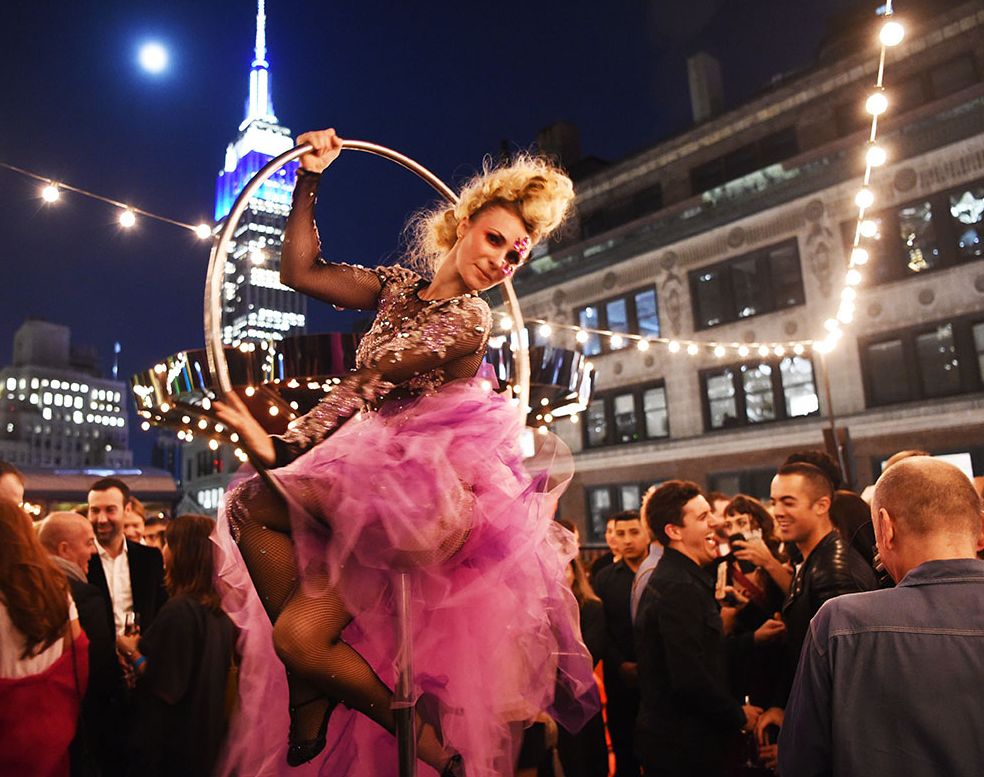 Performer on an aerial hoop at Magic Hour with the Empire State Building behind