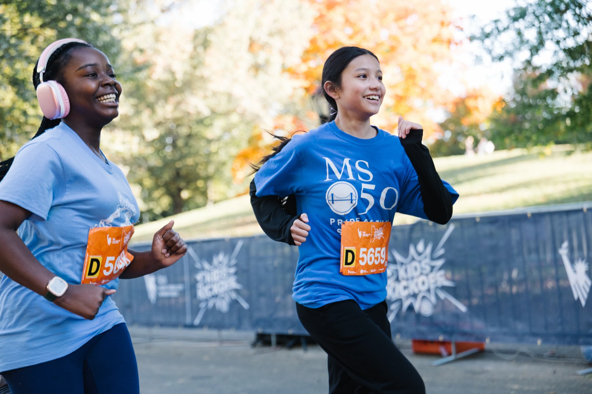 Two young runners smiling during the Kids Kickoff