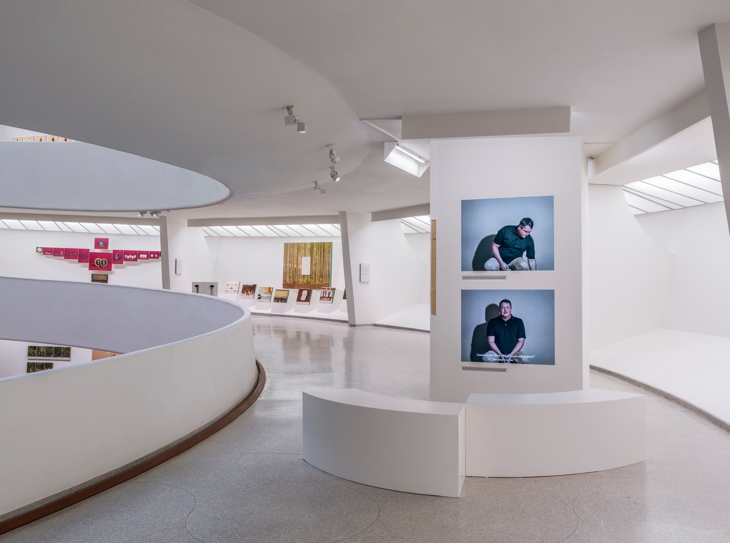 スロープの展示風景と二人の男性の写真作品