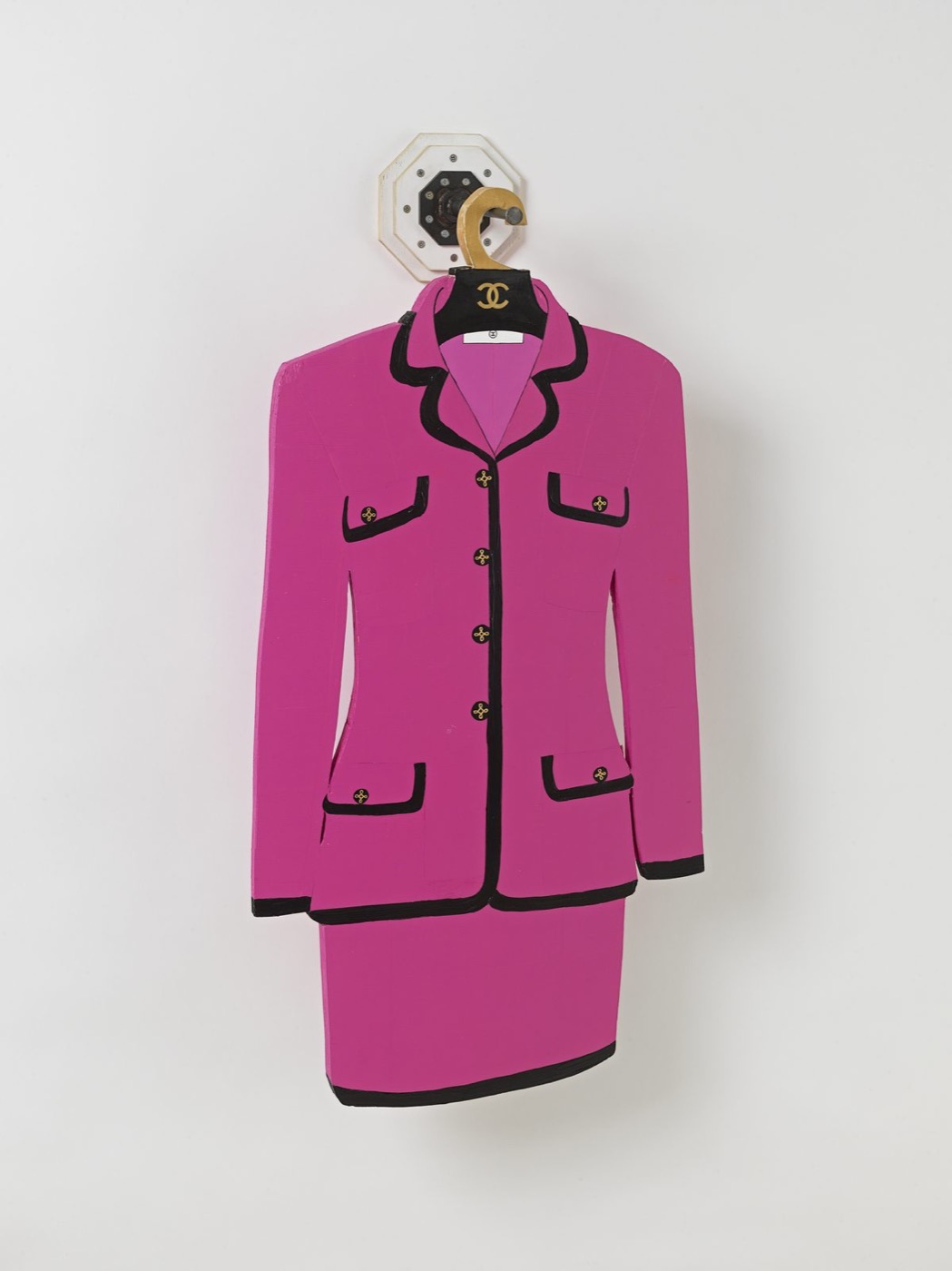 A handmade pink Chanel-style suit on a hanger, by Tom Sachs