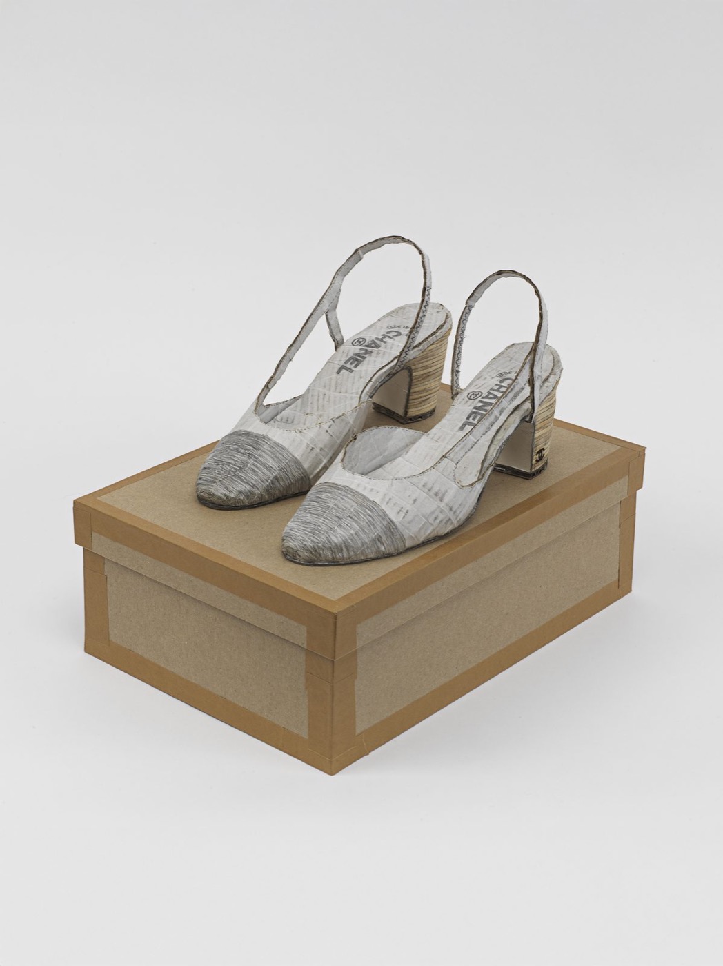 Handmade slingback shoes on a cardboard box