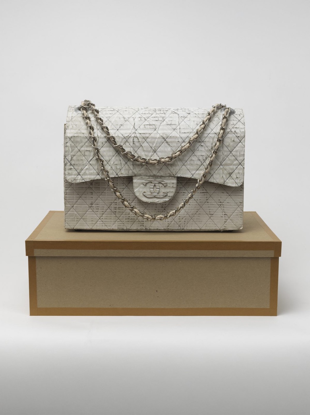 A handmade quilted handbag on a cardboard box