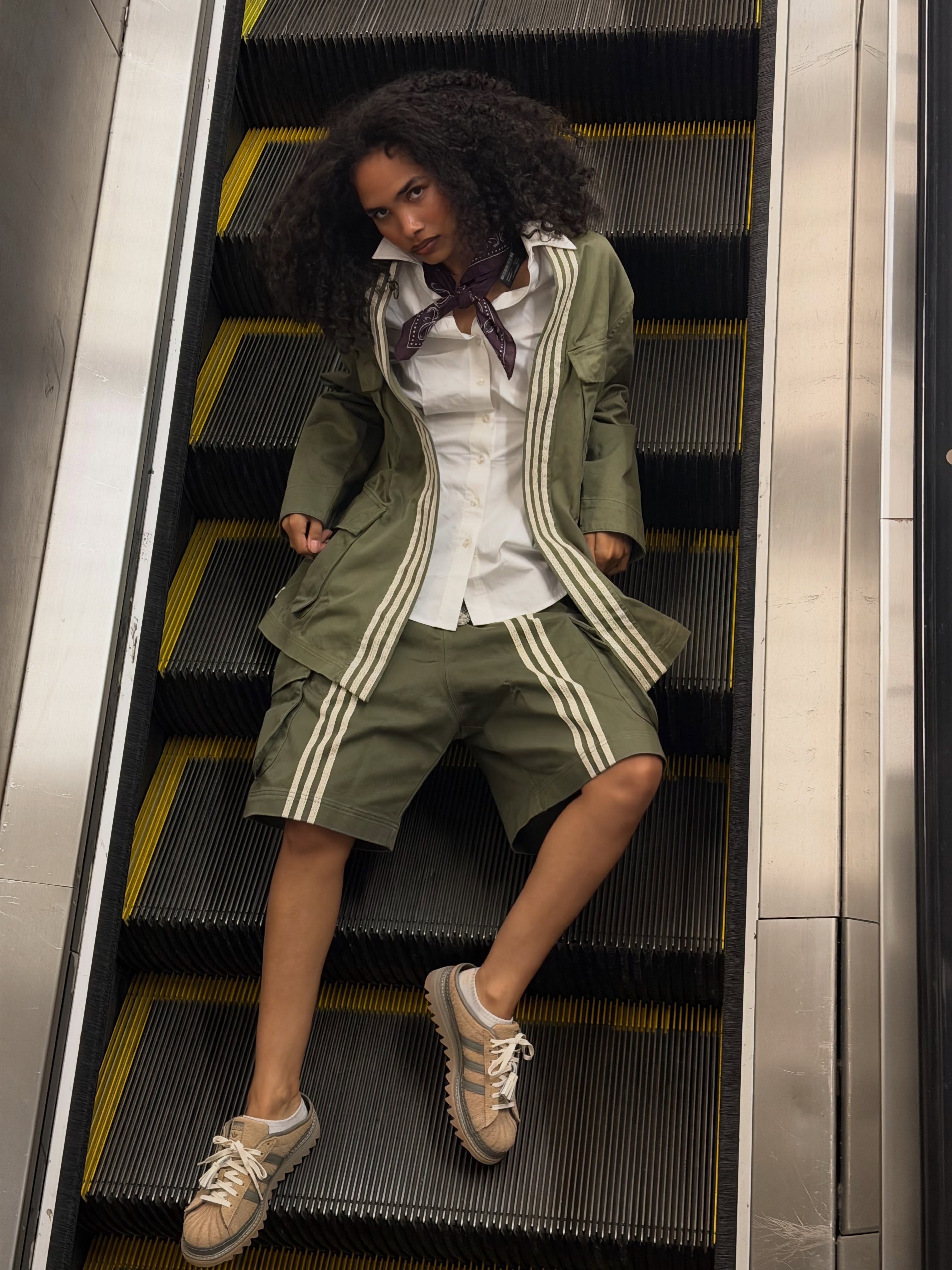 Model in the olive CLOT x adidas jacket and shorts with Superstar sneakers